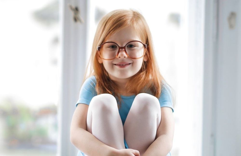child-girl-redhead-smiling-glasses-blue-ballet-dress-1000px